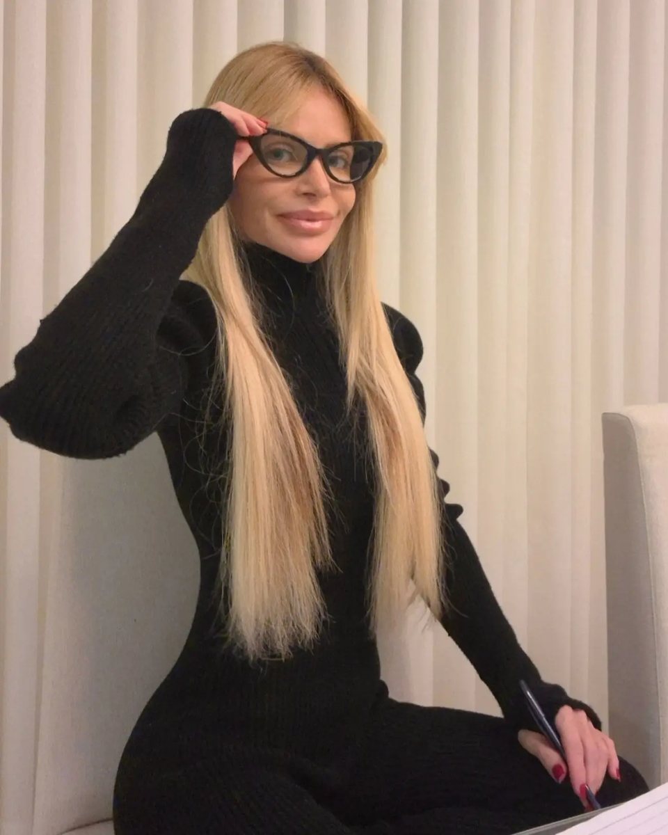 Brizza Aires, de óculos, sentada com seu caderno de anotações